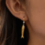 Model wearing 316L stainless steel fish earrings with cubic zirconia